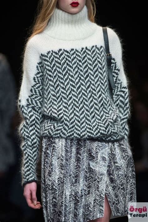 A Model Walks Down The Runway Wearing A Sweater And Skirt