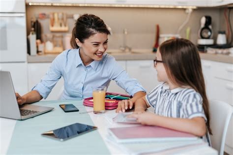 Belle Jeune Mère Aidant Sa Fille Cadette à Faire Ses Devoirs Photo