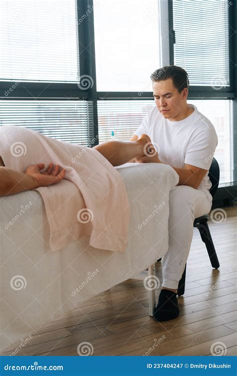 Vertical Shot Of Professional Male Masseur With Strong Hands Massaging