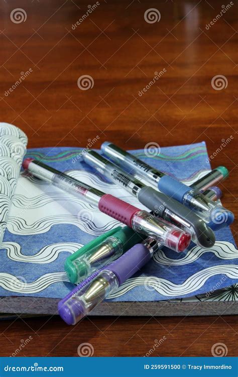 Five Different Colored Metallic Gel Pens Stacked on a Partially Colored ...