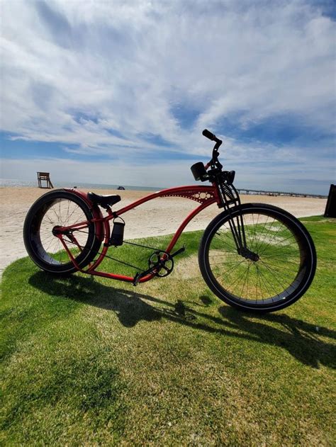 A Red Bicycle Parked On Top Of A Lush Green Field Next To The Ocean