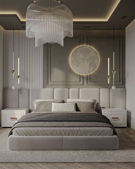 A Large Bed Sitting Under A Chandelier Next To A White Dresser And Mirror