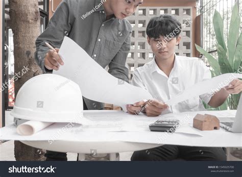 Engineers Pointing Building On Blueprint Drawing Stock Photo 1545025700