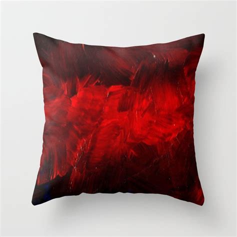 A Red And Black Pillow With An Abstract Design On The Front In White