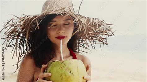 Beautiful Pretty Asian Woman In Hat And Red Dress Drinking Coconut On Tropical Paradise Beach