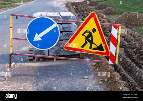 Under Construction Triangle Road Sign And Blue Arrow Sign Stock Photo