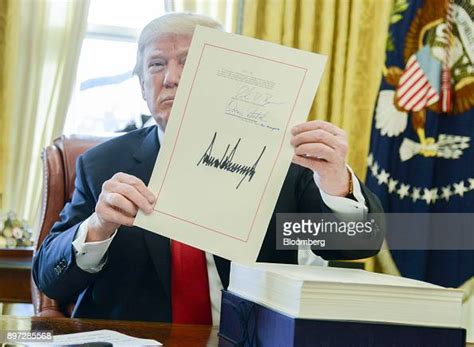 Us President Donald Trump Holds Up A Tax Overhaul Bill After News