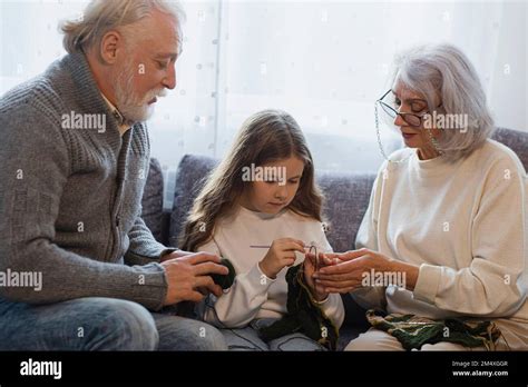 Grands Parents Enseignant Le Crochetage La Petite Fille Sur Le Canap