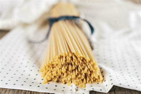 Group Of Uncooked Italian Spaghetti Pasta Tied Together By Blue Silk