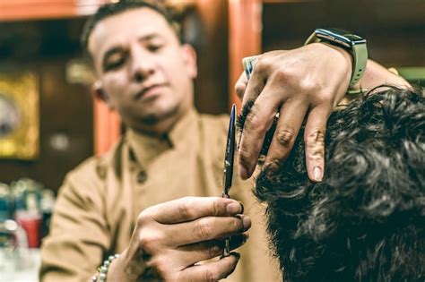 Primer Plano De Las Manos De Un Barbero Cortando El Cabello De Un