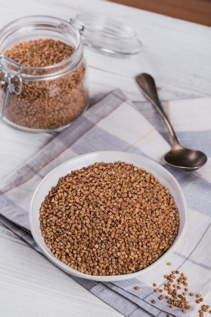 Premium Photo Bowl Of Dry Raw Buckwheat Groats On A White Wooden