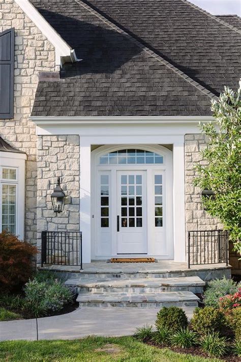 Gray Stone Home Exterior With Seeded Glass Carriage Sconces Cottage Home Exterior