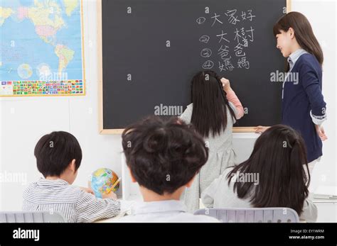 Young teacher teaching and smiling in the classroom Stock Photo - Alamy