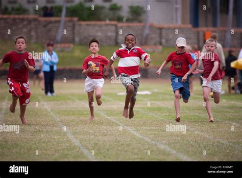 Primary School Children Running In Inter House Athletics Race Stock