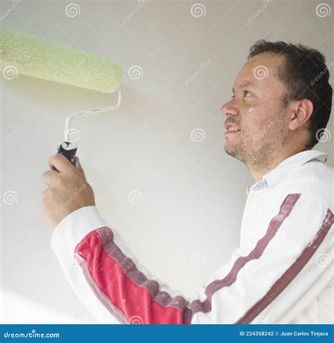 Male House Painter Worker Painting And Priming Wall With Painting