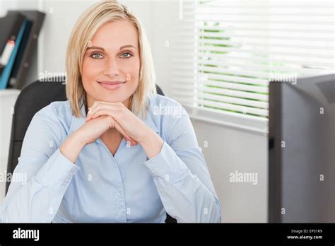 Cute Blonde Woman With Chin On Her Hands Behind A Desk Stock Photo Alamy