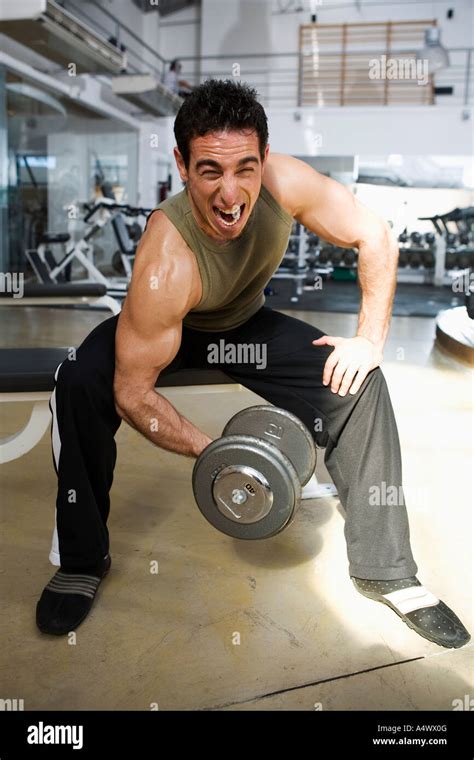 Man lifting weights at a gym Stock Photo - Alamy