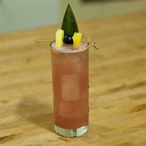 A Tall Glass Filled With A Drink On Top Of A Wooden Table