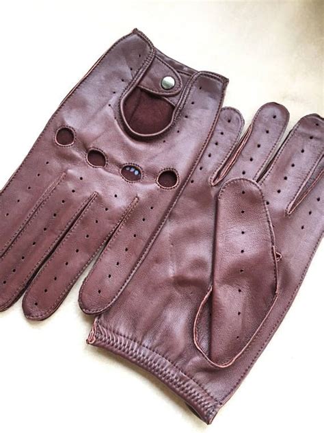 a pair of brown leather gloves sitting on top of a table