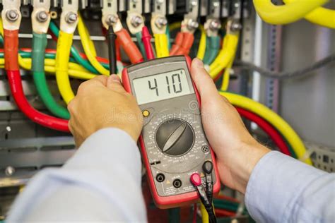 Multimeter In Hands Of Electrician In Power High Voltage Three Phase