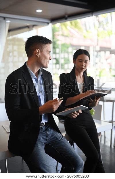 Two Business People Sitting Each Other Stock Photo