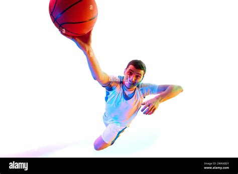 focused young man basketball athlete  dynamic dunk pose