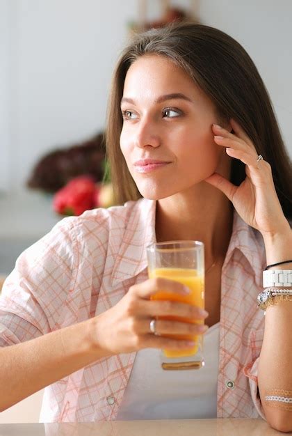 Mujer Joven Sentada En Una Mesa En La Cocina Foto Premium