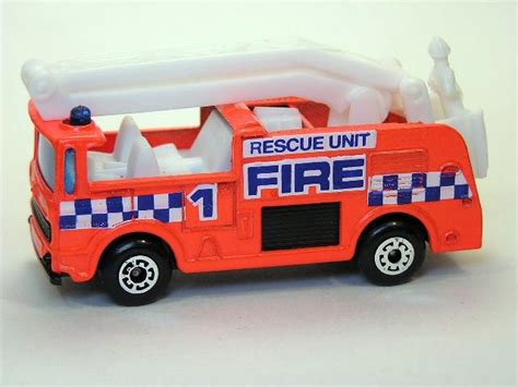 An Orange Toy Fire Truck Sitting On Top Of A White Table