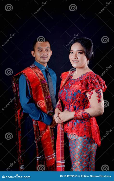 Portrait Of Beautiful Indonesian Couple Wearing Traditional Batak Costume Isolated On Black