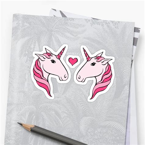 two pink unicorn stickers next to a pencil