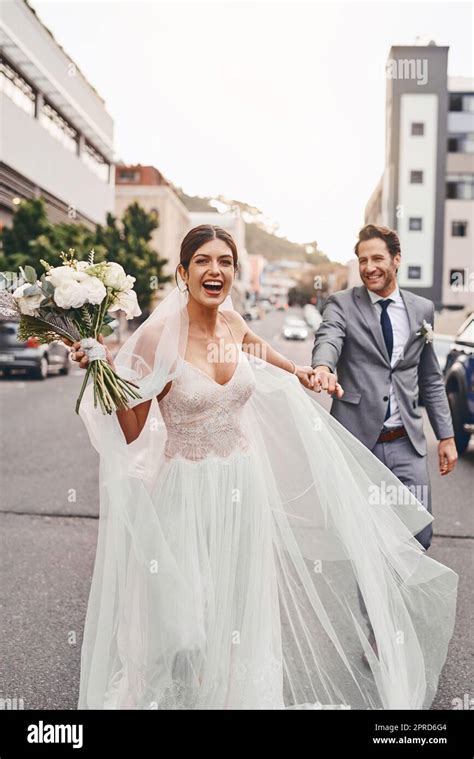 The Bride Is Running Away With Her Groom A Beautiful Couple Out In The City On Their Wedding