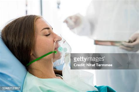 Shot Of Unconscious Woman Patient Laying Down In Hospital Bed Wearing