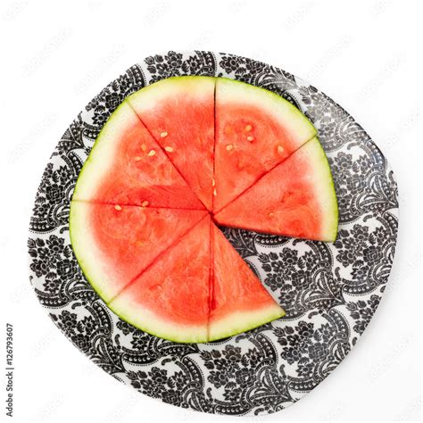 Watermelon slices on a black and white plate on a white background ...