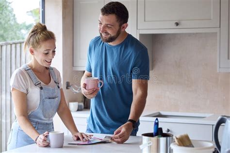 Couple Renovating Kitchen At Home Looking At Paint Swatches On Coffee Break Stock Image Image