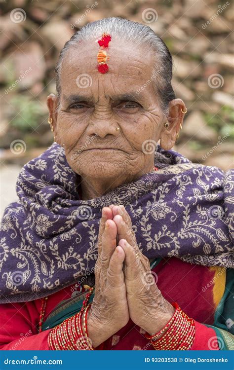 Portrait Old Woman In Traditional Dress With Folded Hands In Street