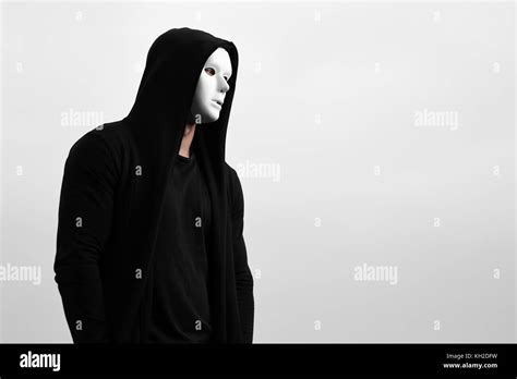 Portrait Of Man In Black Hoodie Wearing White Anonymous Mask Stock