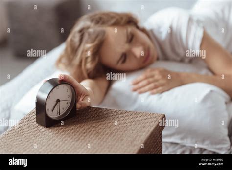 Sleepy Woman Turning Off Her Alarm Clock Stock Photo Alamy