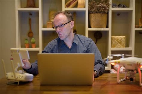 Premium Photo Man Using Mobile Phone While Sitting On Table