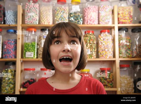 Young Girl Looking In Awe At Rows Of Sweets Stock Photo Alamy