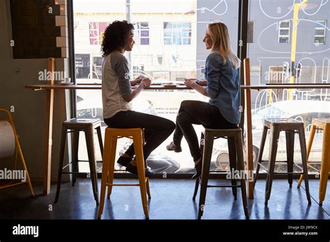 Two Female Friends Meeting In Coffee Shop Stock Photo Alamy