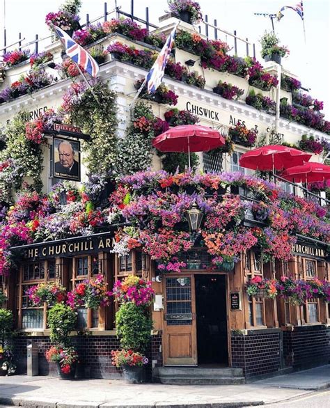 The Outside Of A Building Covered In Flowers And Hanging From It S Roof