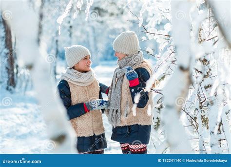 Beautiful Teenage Girls Twins Sisters Having Fun Outside In A Wood With Snow In Winter