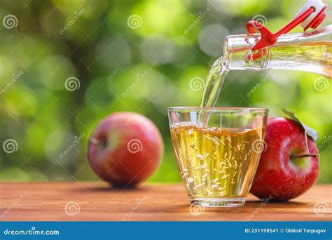 Appelcider Of Appelsap Dat In Glas Uit Flessen Giet Stock Afbeelding