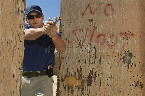 Homem Que Aponta a Arma Da Mão Na Escala De Acendimento Foto de Stock