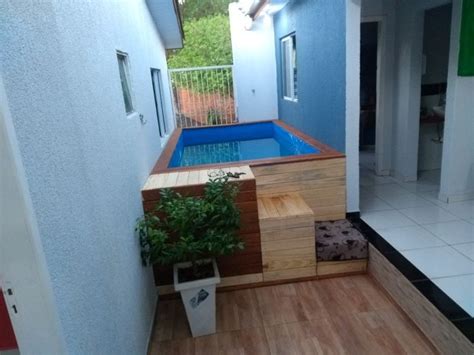 An Indoor Swimming Pool In The Middle Of A Room With Wood Flooring And