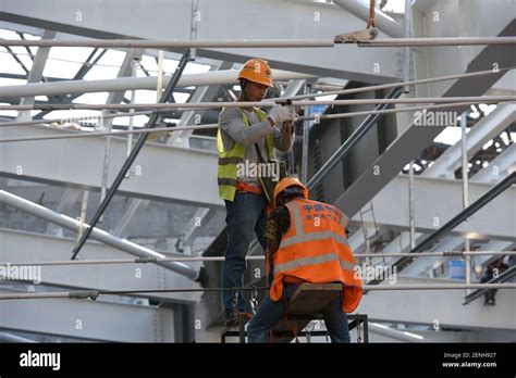 Chinese Migrant Workers Mount Electrified Devices At The Construction