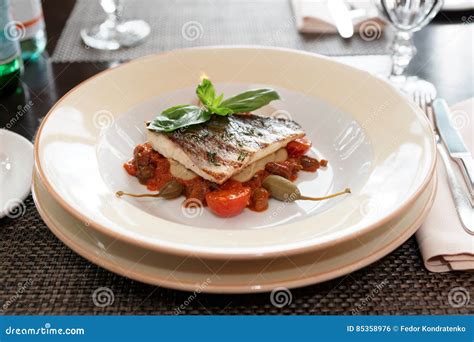 Sea Bass Fillet with Tomato Sauce and Capers Stock Photo - Image of ...