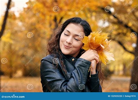 Pretty Woman Is Posing With Bunch Of Maple`s Leaves In Autumn Park She