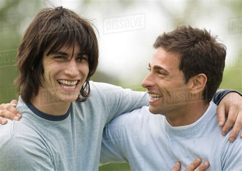 Two Young Male Friends Smiling With Arms Around Each Others Shoulders