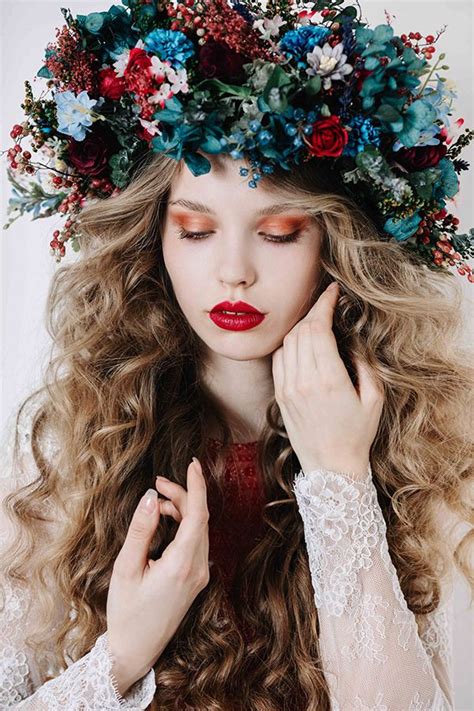 A Woman With Long Curly Hair Wearing A Flower Crown On Her Head And Red